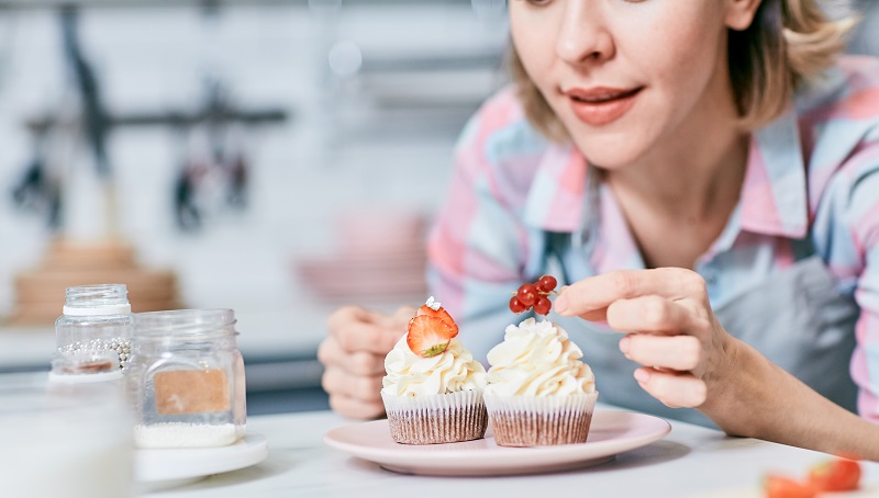 mujer decorando muffins