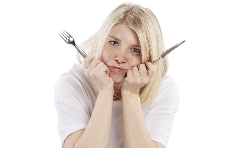 Mujer aburrida con cubiertos