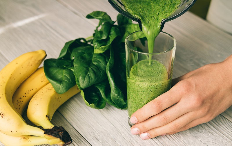 mujer sirviendo batido verde
