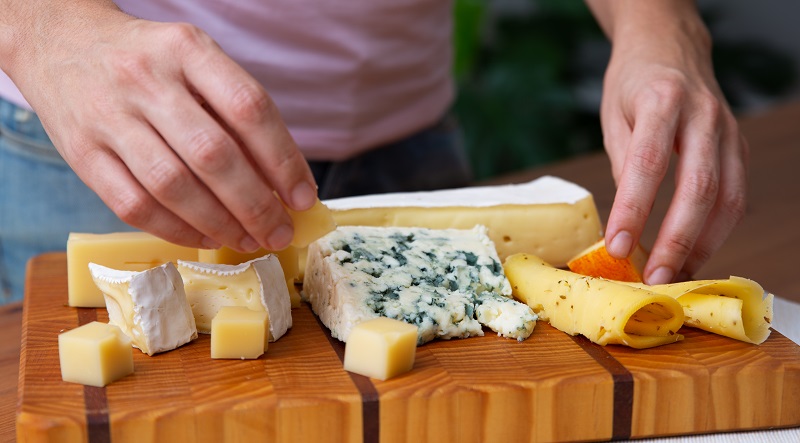 mujer acomodando queso en tabla