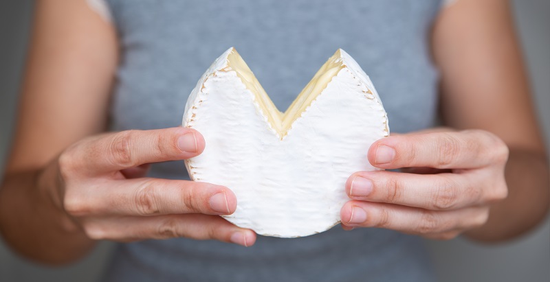 mujer sosteniendo bloque de queso